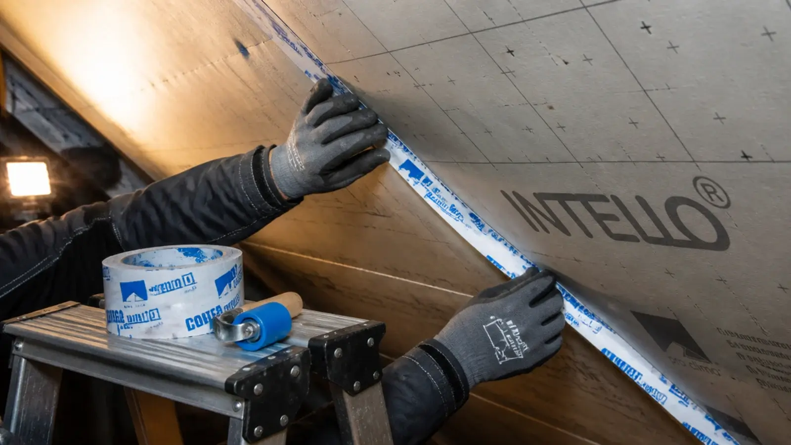 airtight tape being applied to board joints on an attic ceiling slope