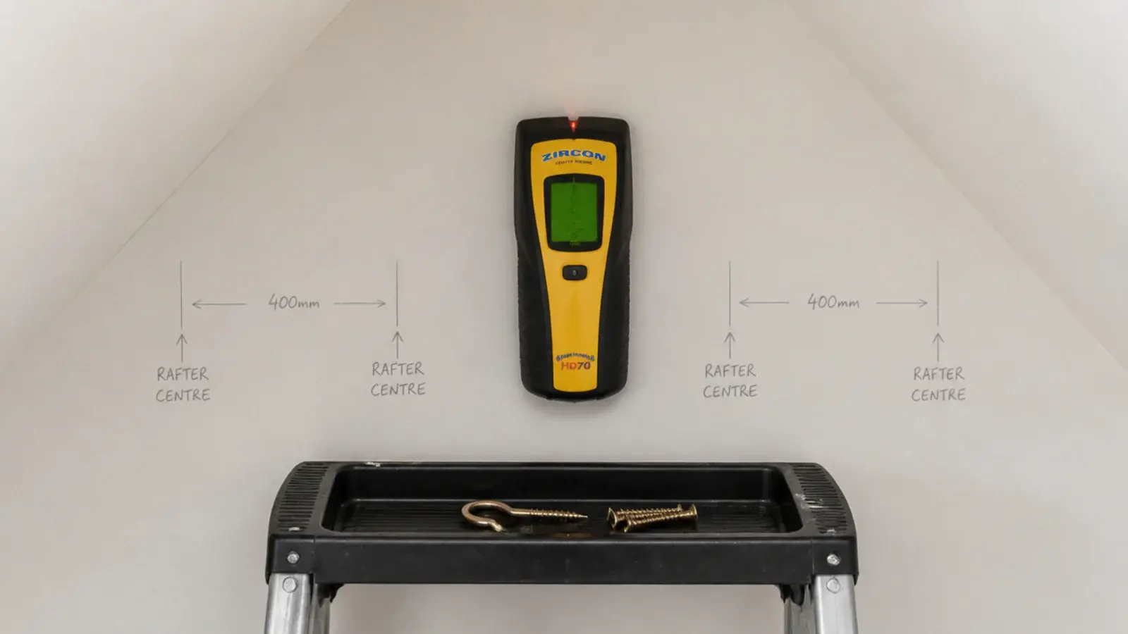detector held against a sloped ceiling with rafter positions marked