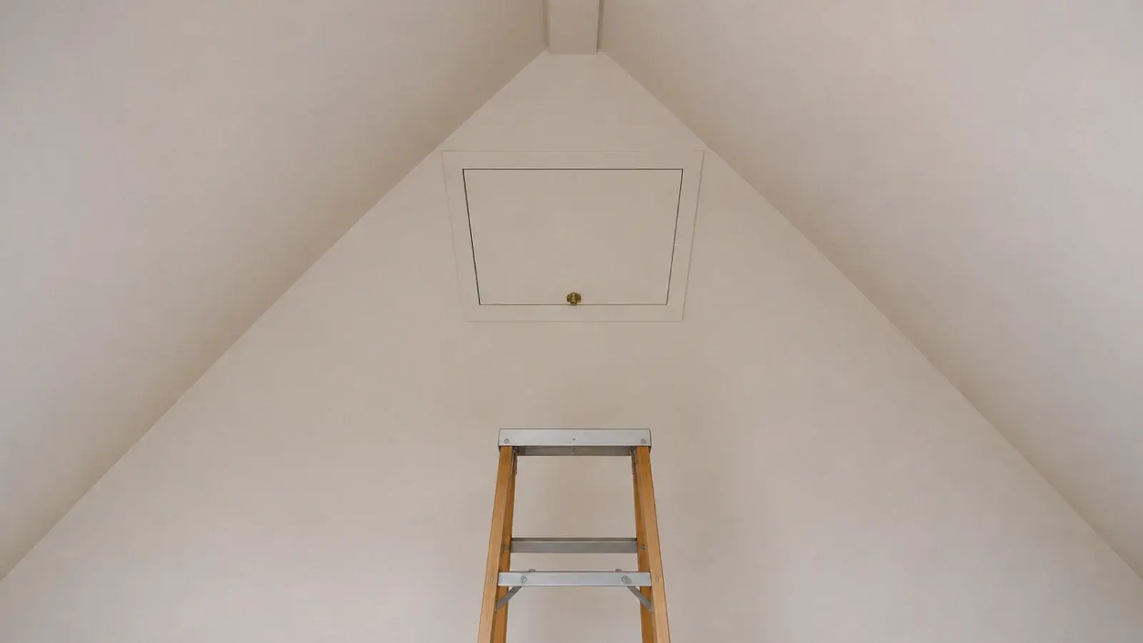 small painted access hatch set into a sloped attic bedroom ceiling