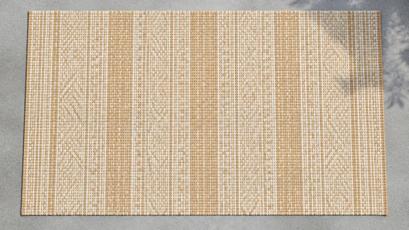 open weave outdoor rug in sand tones covering a small balcony floor