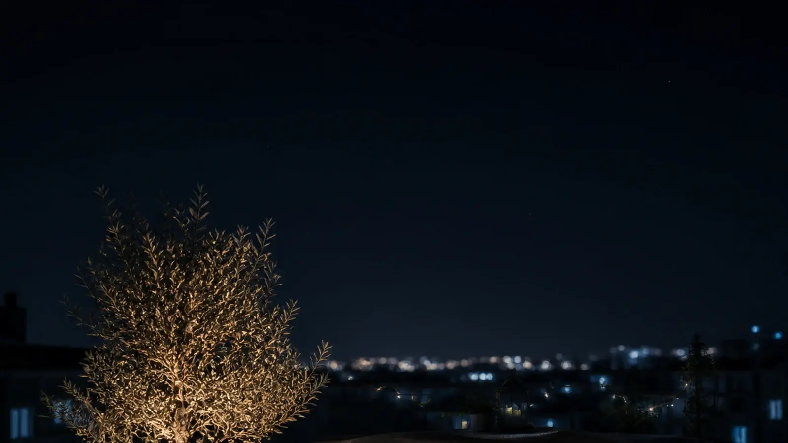 vertical view of renter friendly apartment balcony lighting glowing at night