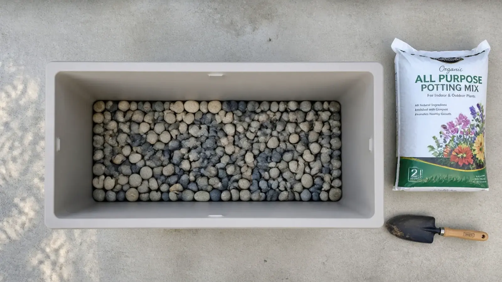 flat stones layered in the base of a lightweight balcony planter