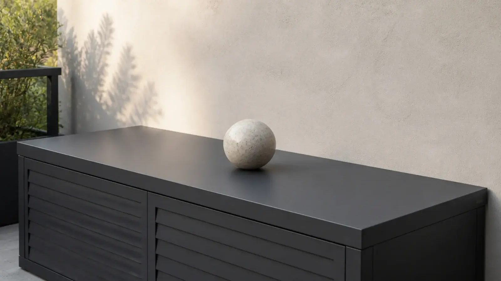 single pale stone sculptural object sitting on a modern balcony bench