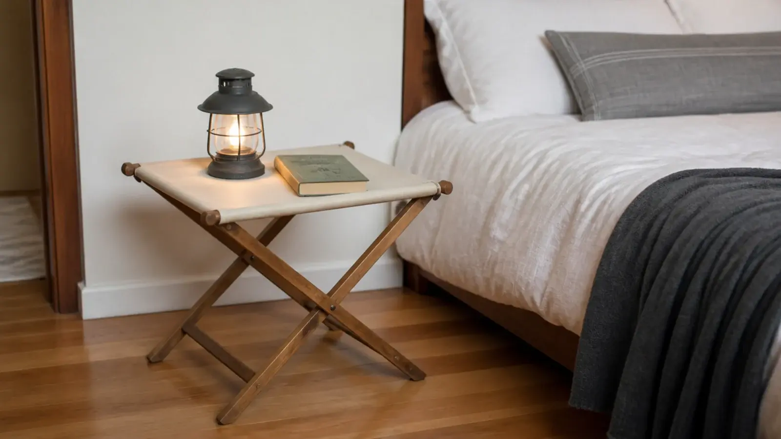 canvas and timber folding camp table set up beside a bed