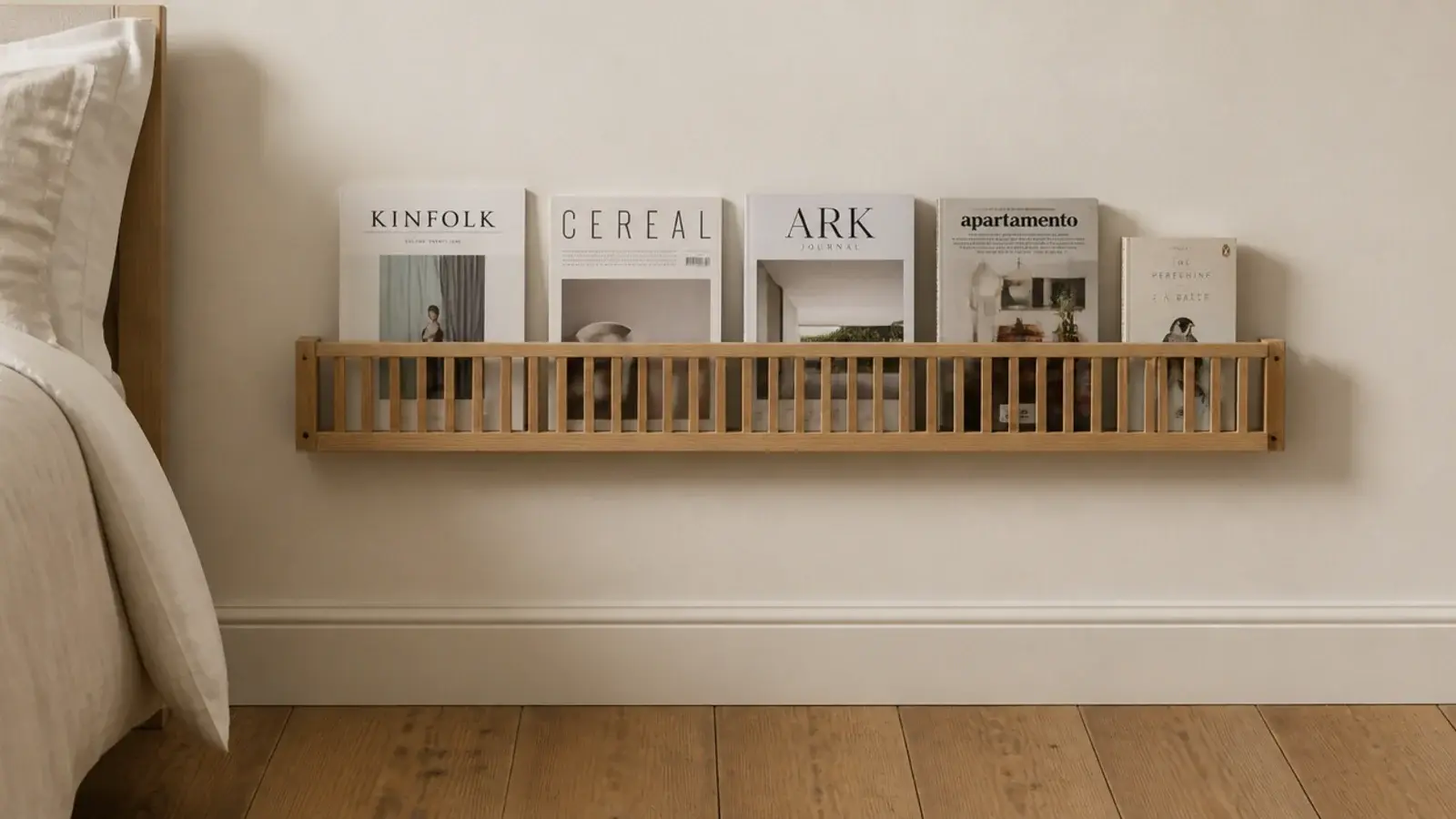 timber magazine rack fixed to a wall holding books beside a bed