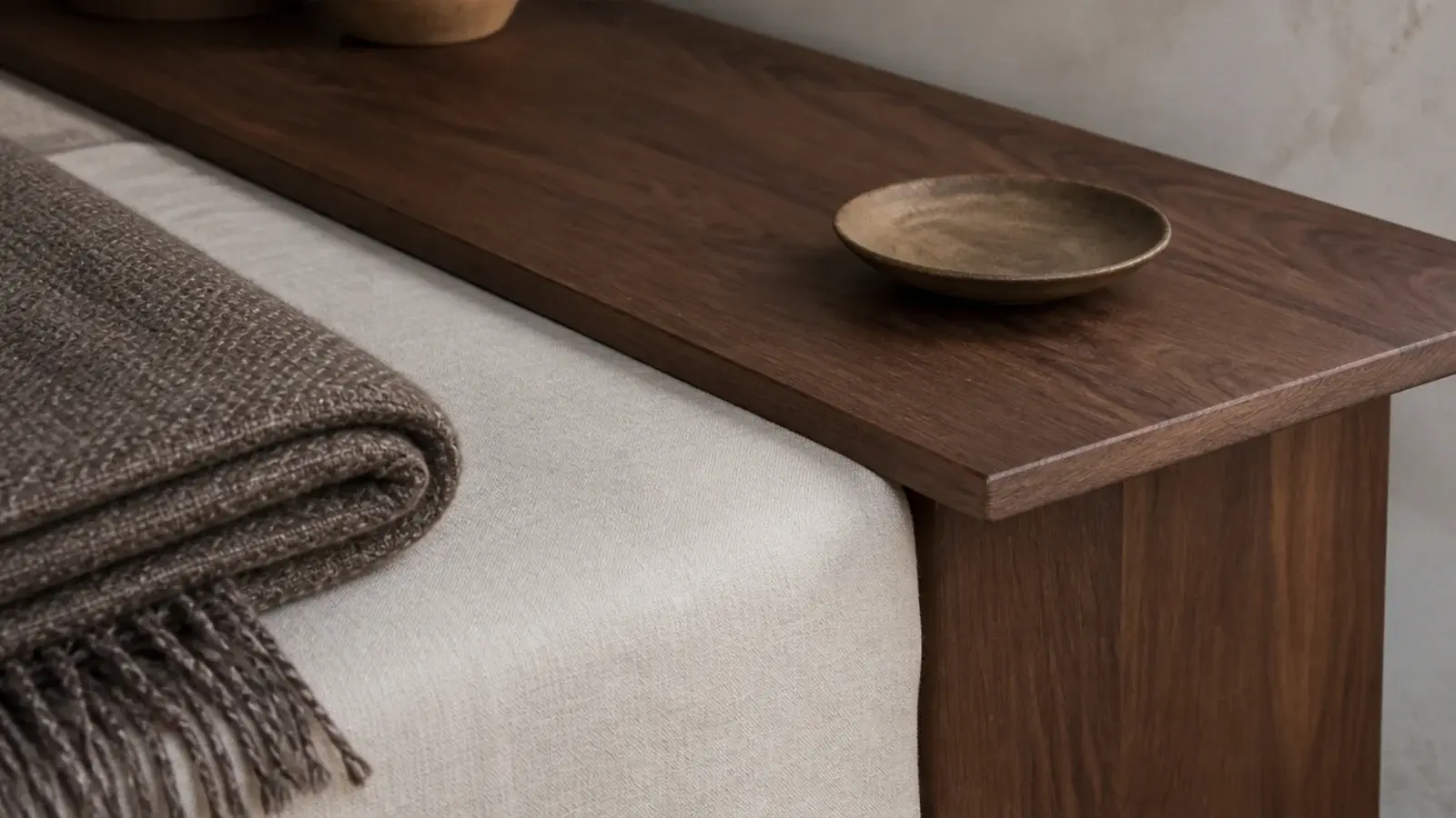 bedside table top sitting level with the edge of a made bed