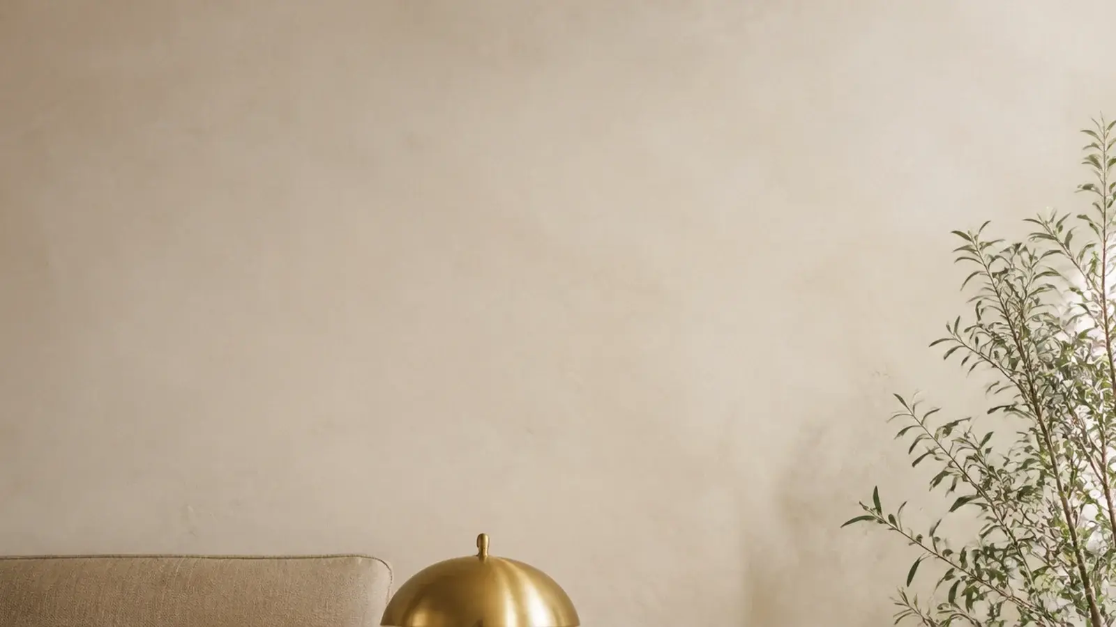 tall view of styled bedside table ideas with lamp book and trailing plant