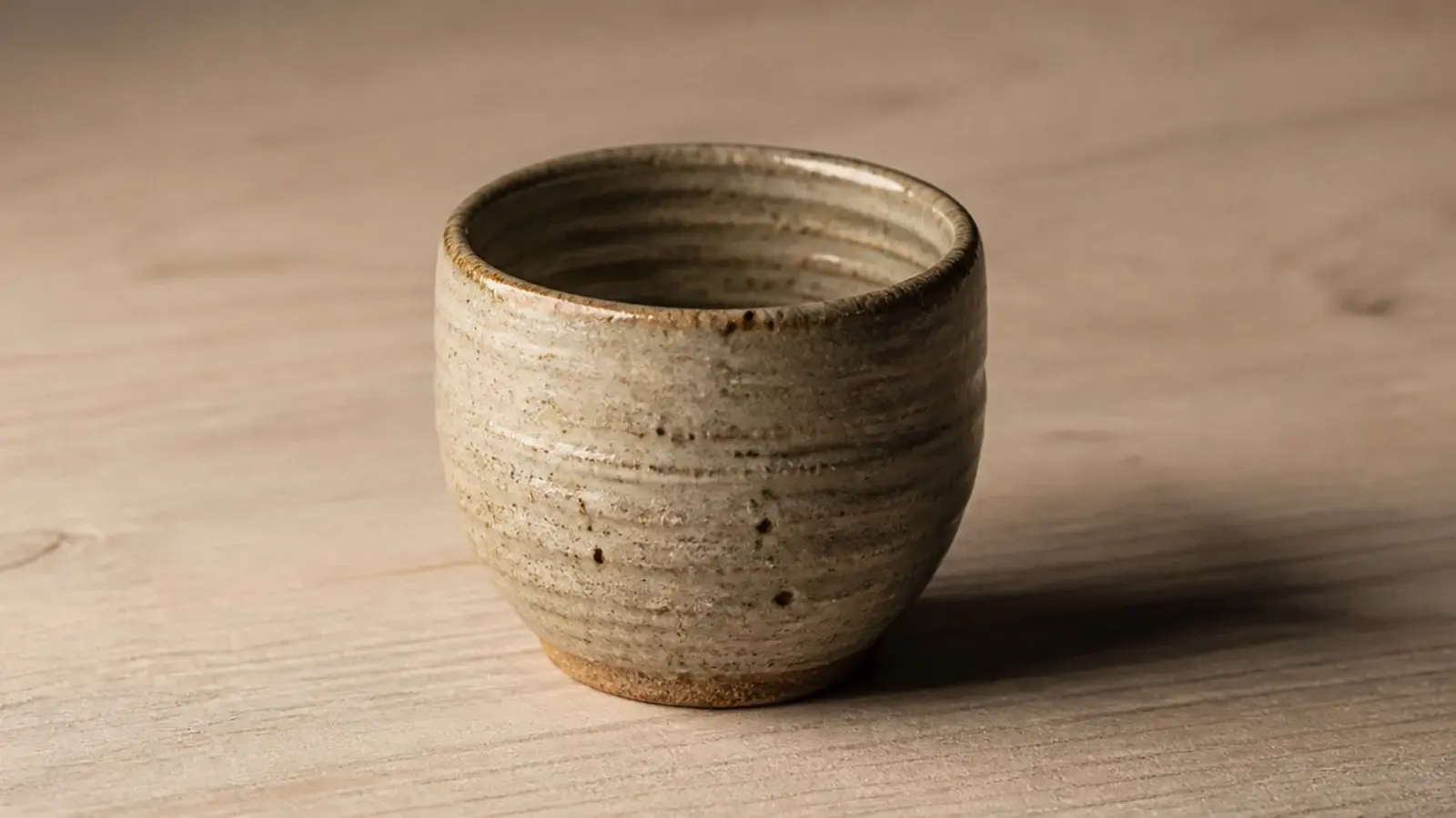 slightly uneven handthrown cup showing visible potter thumb marks