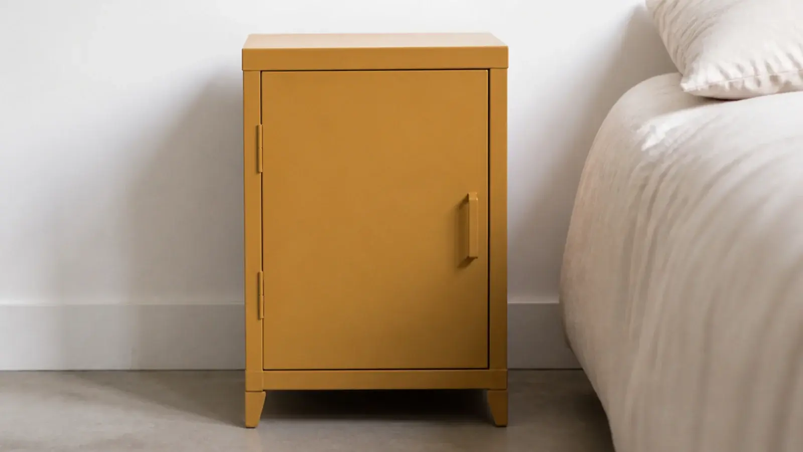 bright ochre powder coated steel bedside cabinet against a white wall
