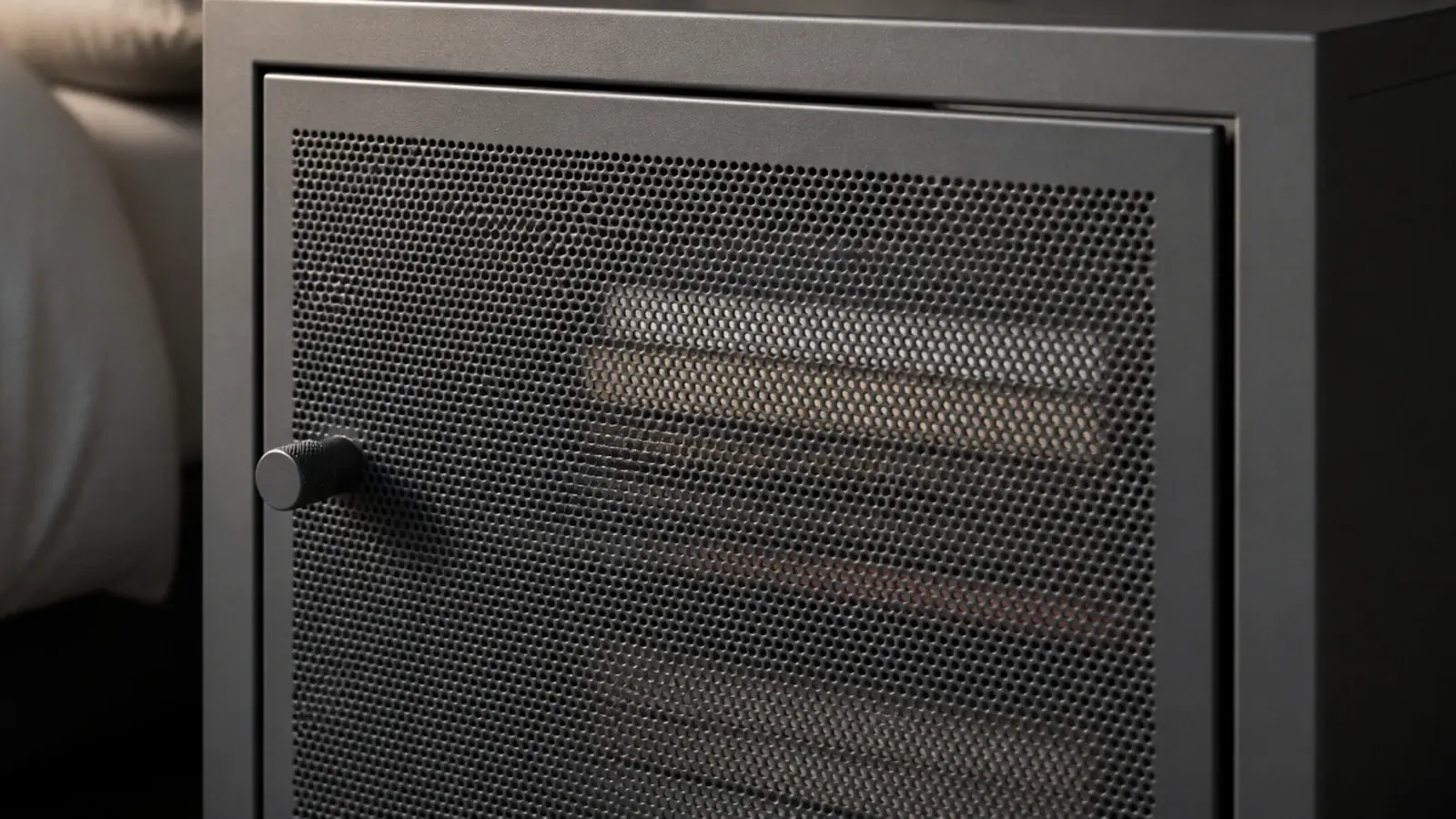 perforated steel cabinet door partly concealing books stacked inside