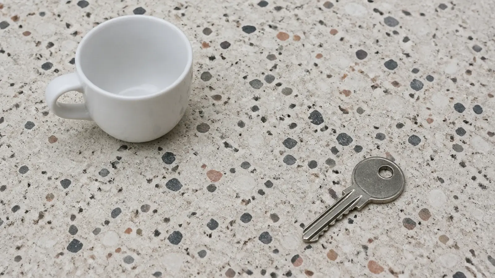 pale terrazzo bedside top scattered with small dark stone chips