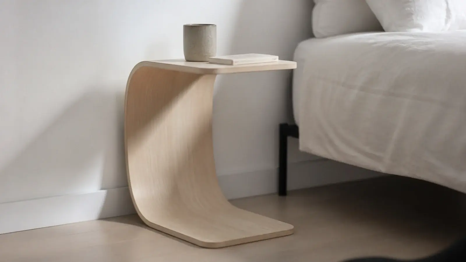 single sheet of bent plywood curving from floor to bedside top