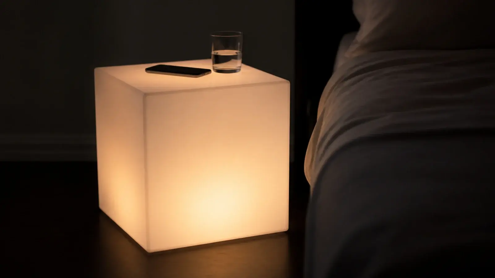 translucent acrylic bedside cube lit softly from the inside at night