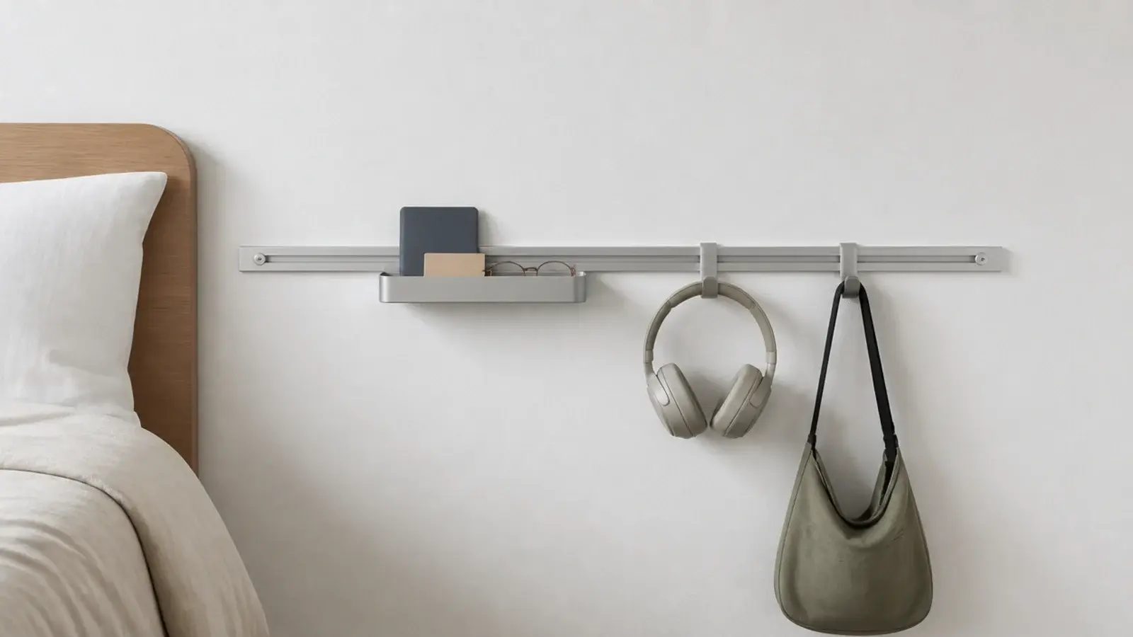 metal wall rail beside a bed carrying a small tray and two hooks
