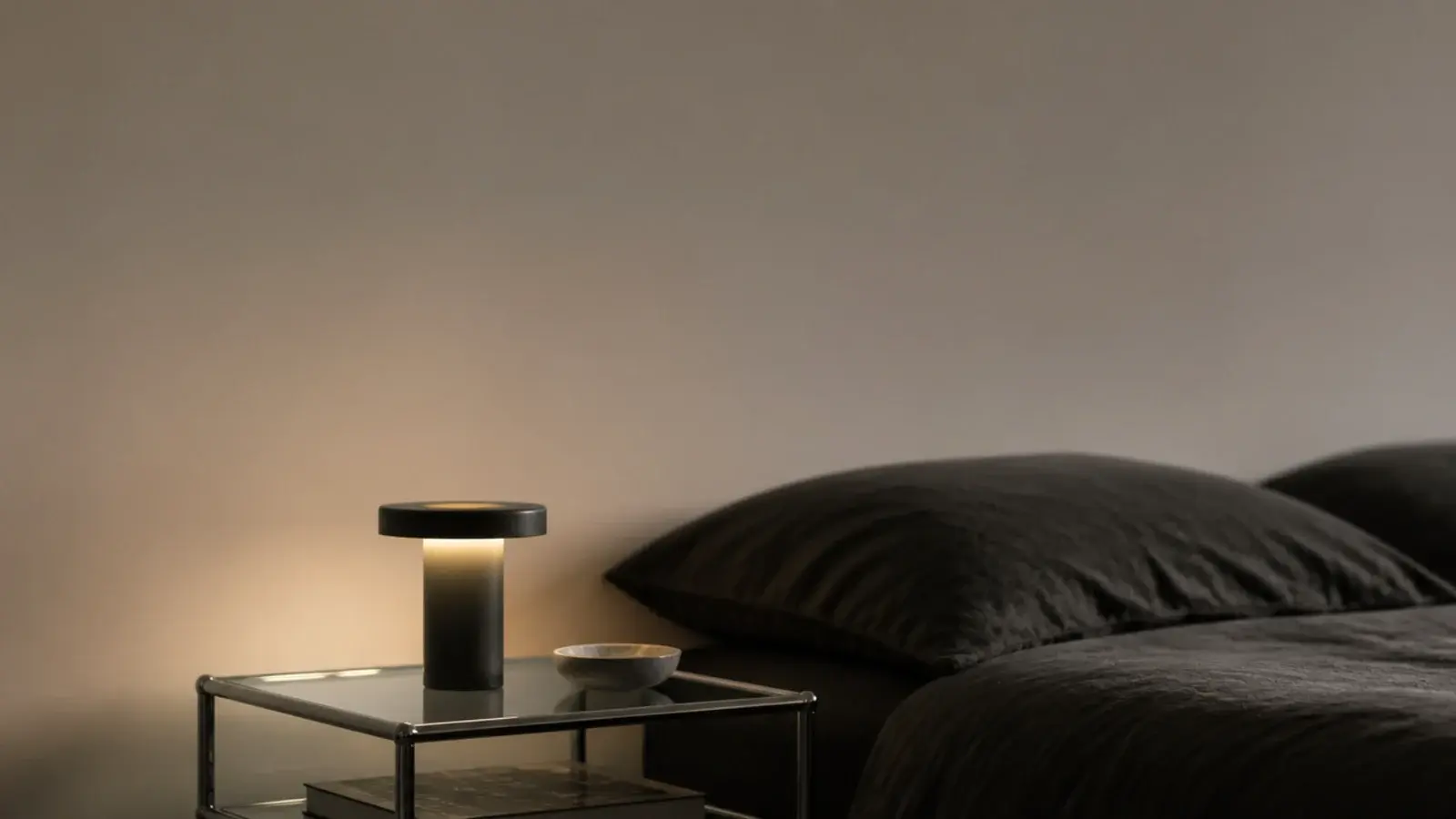 tall modern bedside table view with glass steel and a cordless lamp