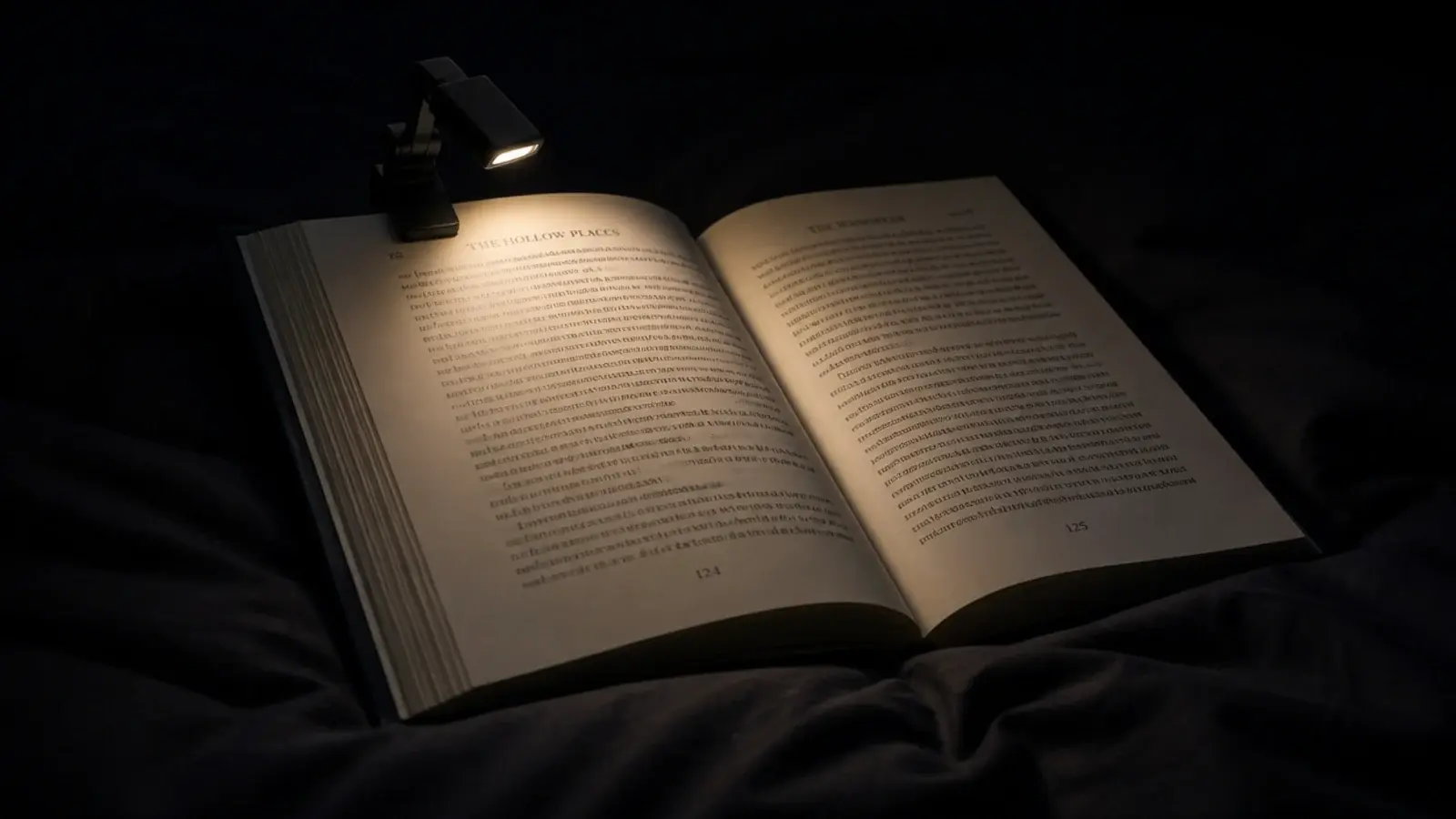 compact clip light gripping a hardback cover with a narrow warm beam