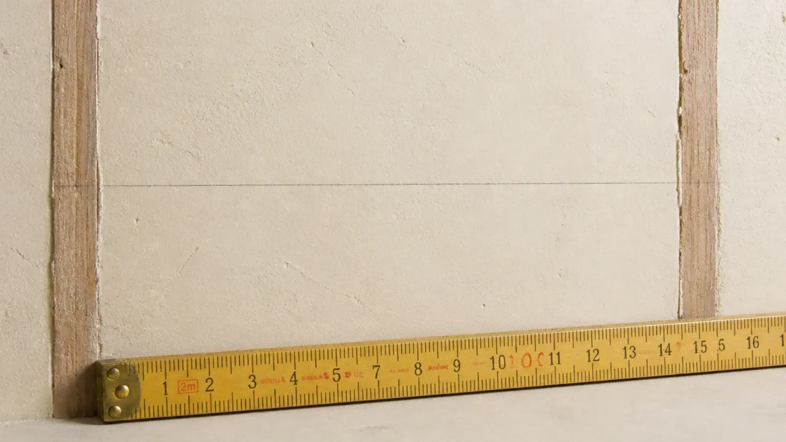 pencil line drawn between two marked stud positions on a wall