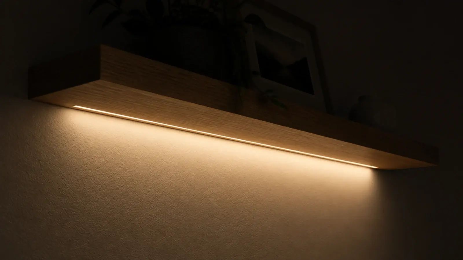 warm light glowing from beneath a floating bedside shelf at night