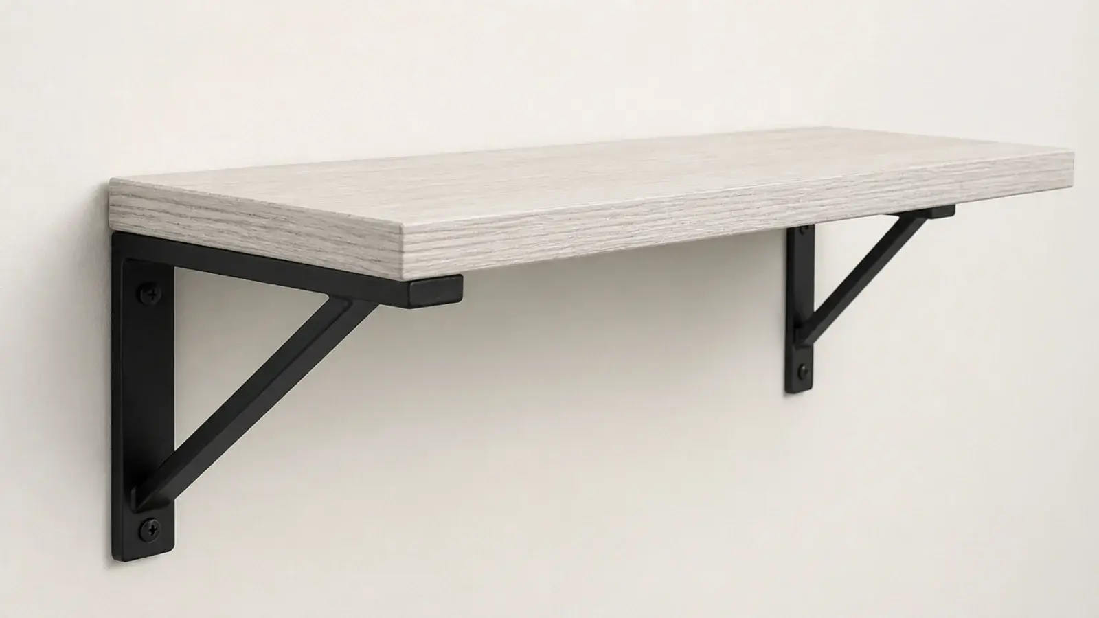 exposed black metal bracket supporting a pale timber bedside shelf
