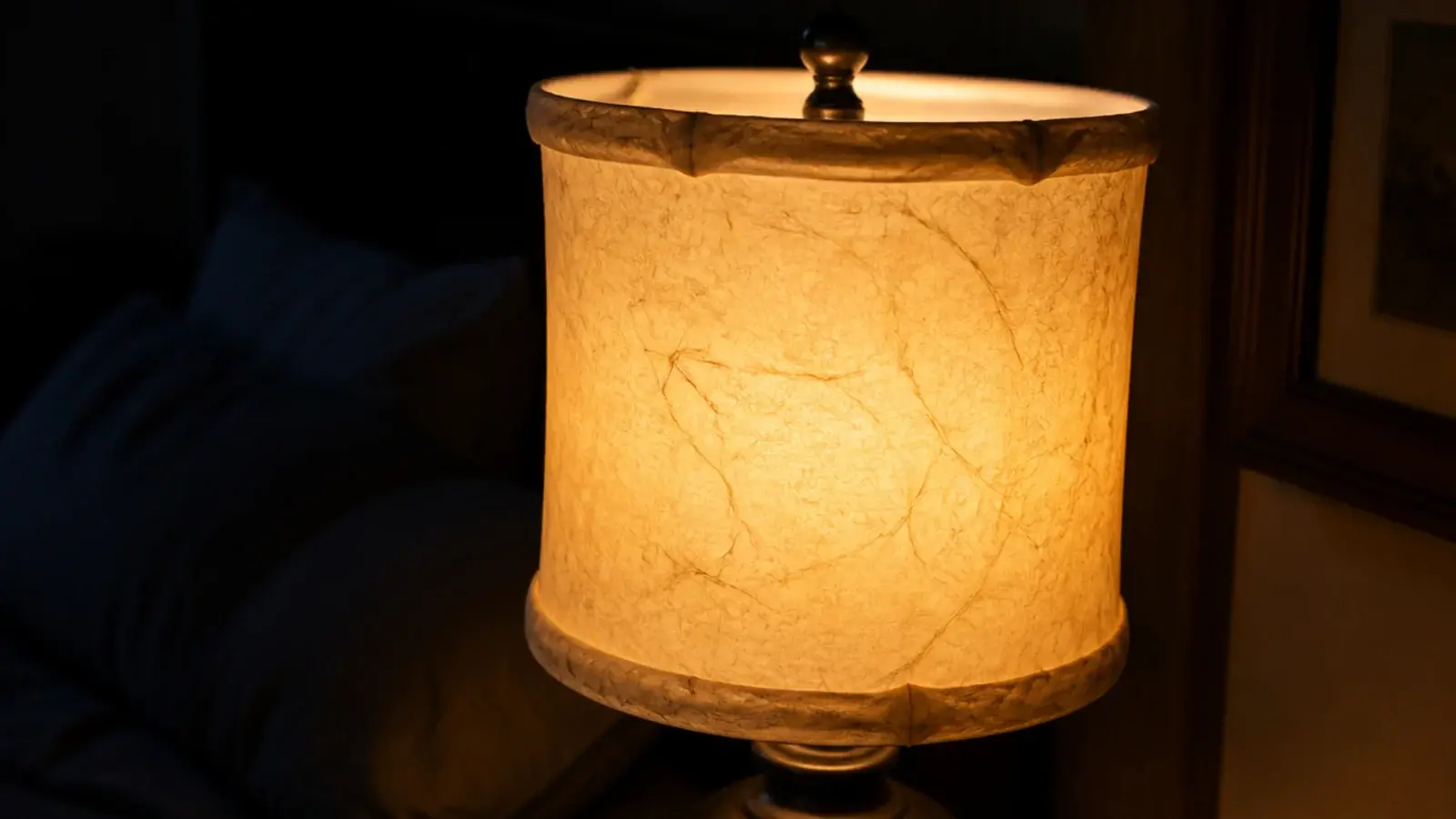 lit lampshade in parchment showing a hand-rolled seam and warm glow
