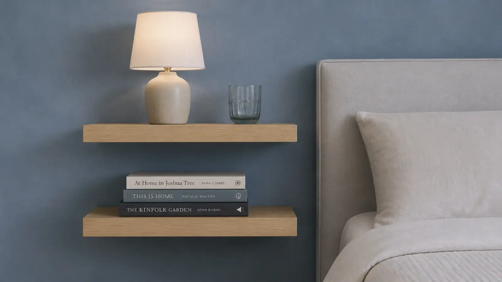 two stacked shallow shelves beside a bed holding separate items