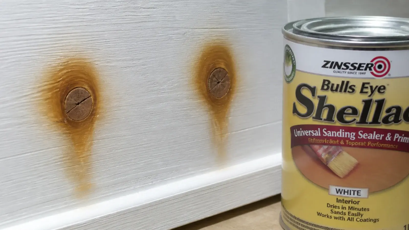 brown tannin rings showing through white paint above pine knots