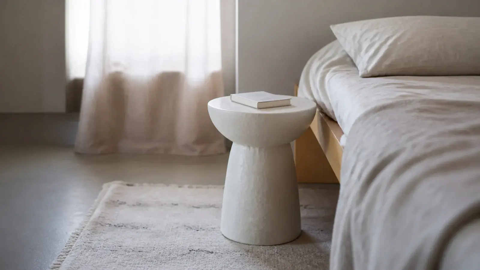 matte white plaster pedestal table with a softly irregular hand formed surface