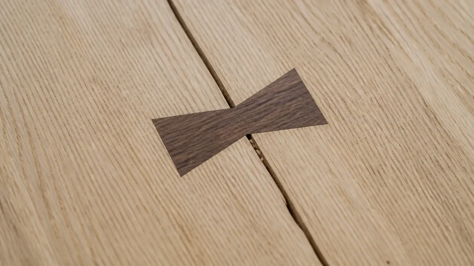 dark butterfly key inlaid across a split in a pale timber top