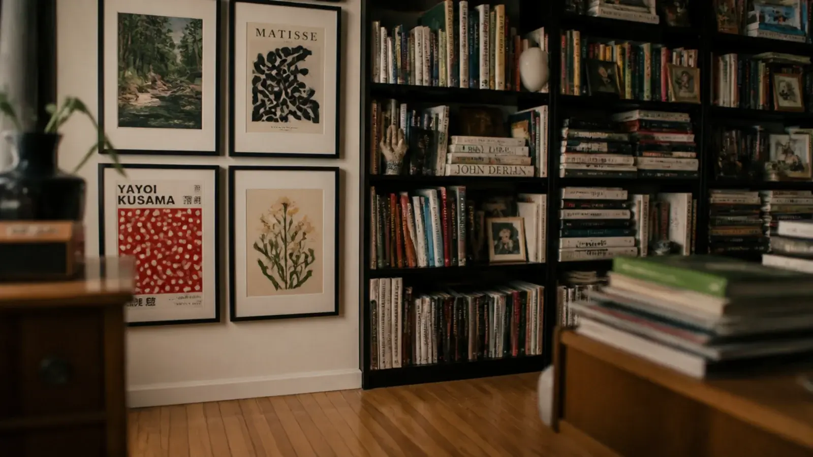 framed prints crowded beside a full bookcase competing on one wall
