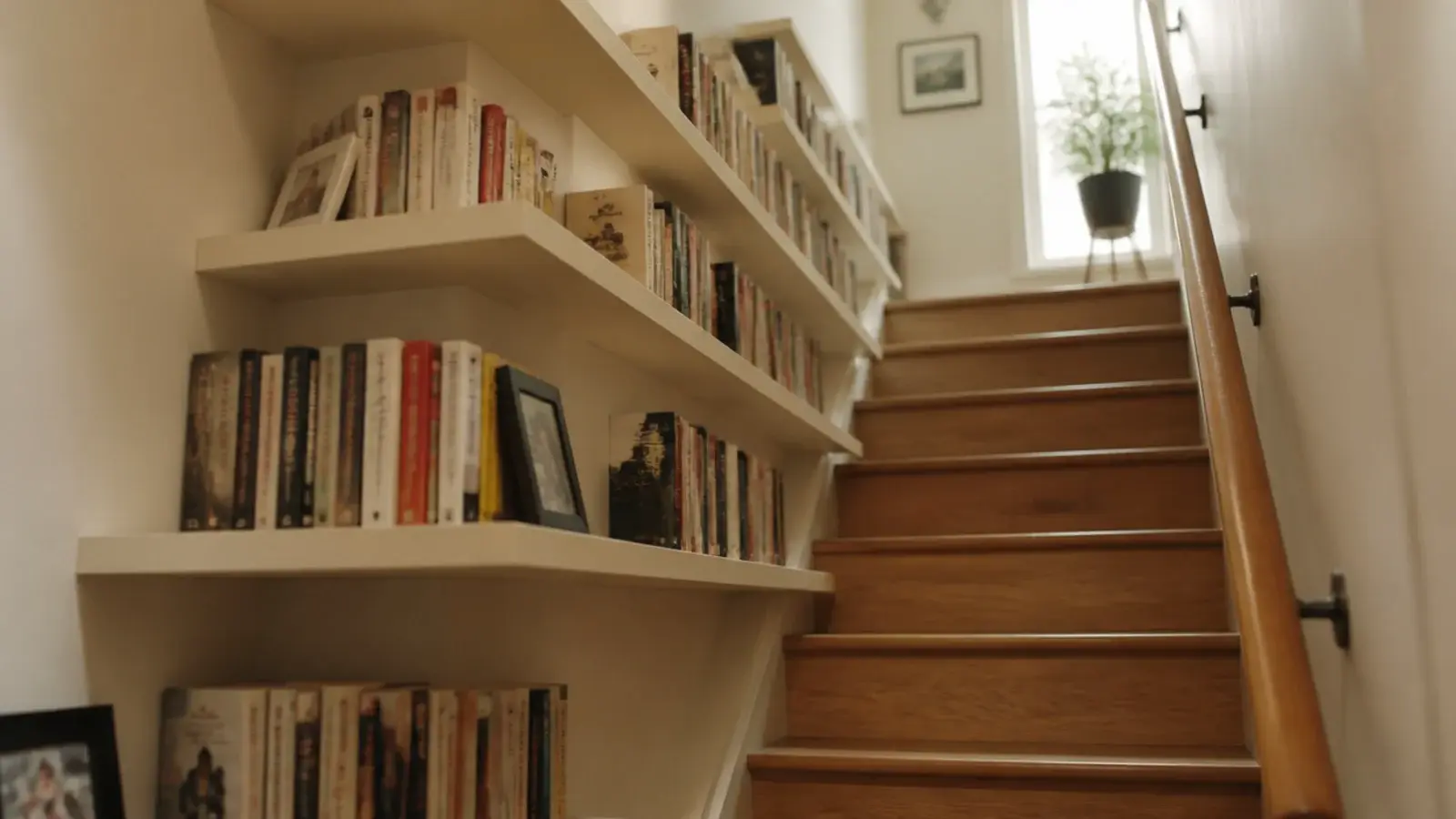 shallow shelves climbing a stairwell wall stepped with the staircase