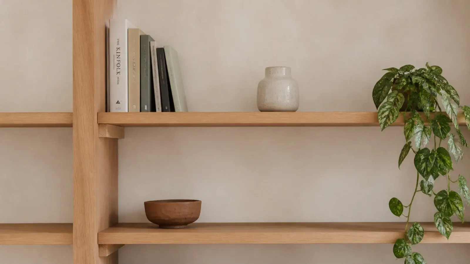 minimalist bookshelf styled with three objects wide gaps and pale oak boards