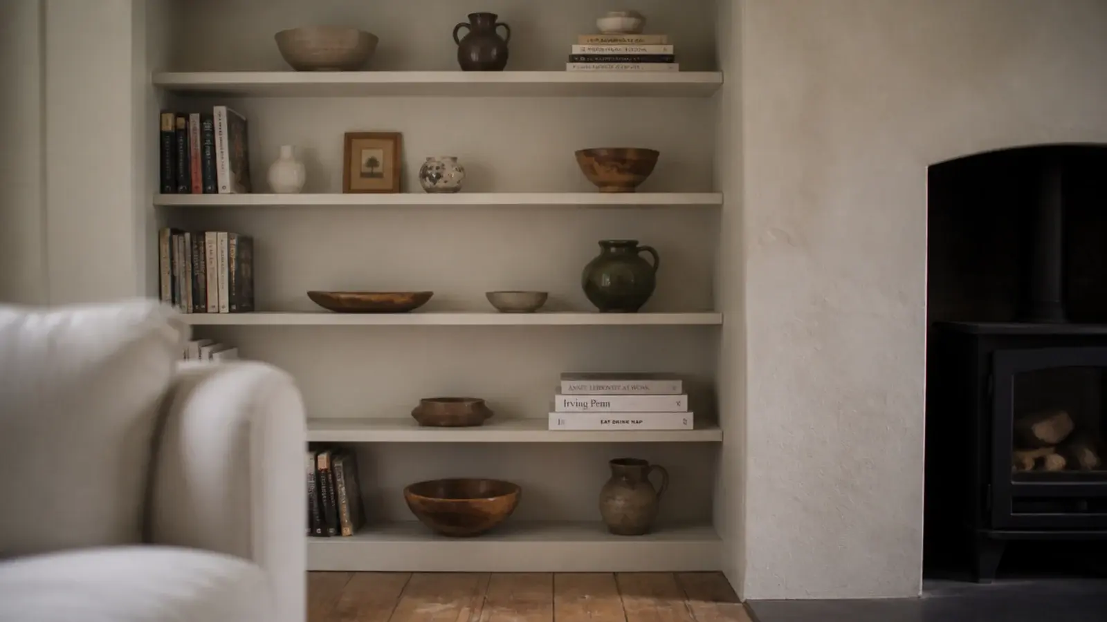 fitted shelves filling the alcove beside a chimney breast with books