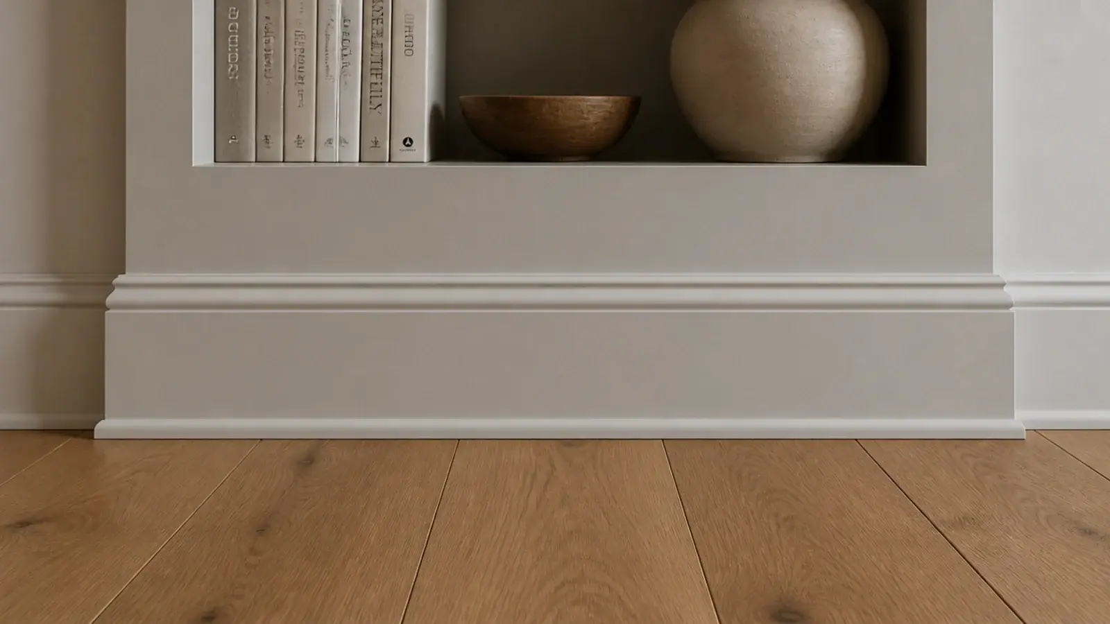 toe kick plinth wrapped in matching baseboard beneath white built in shelves