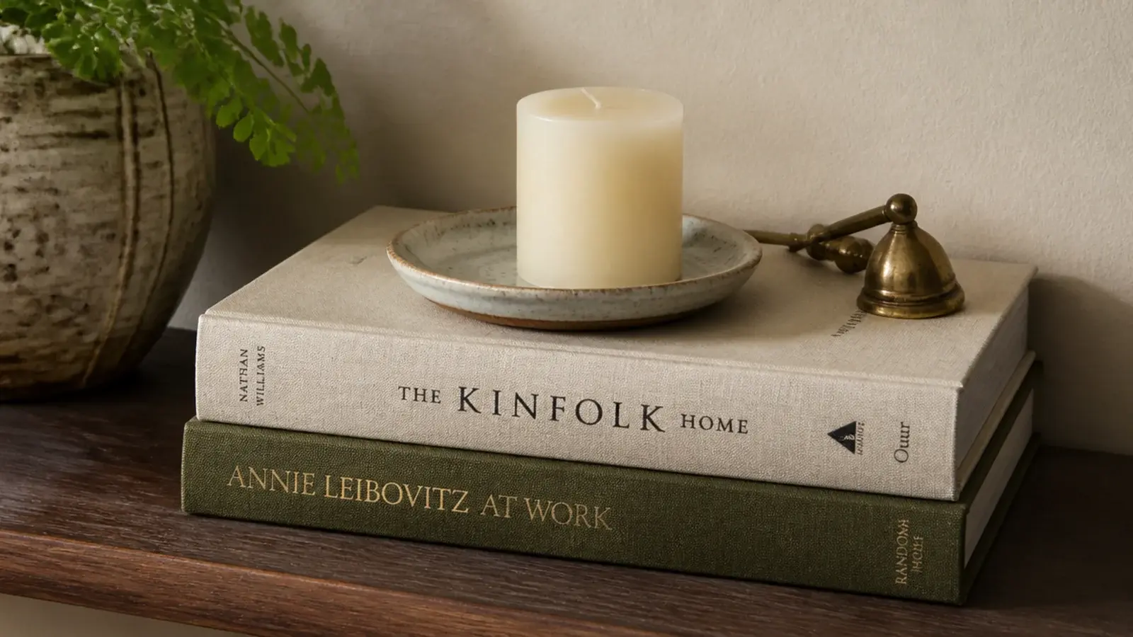 candle raised on stacked books with a ceramic dish between them