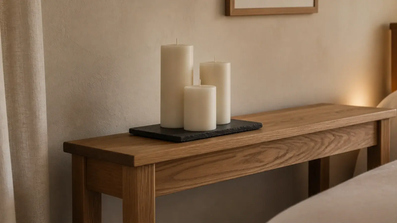 plain unscented ivory pillars glowing on a simple bedroom console