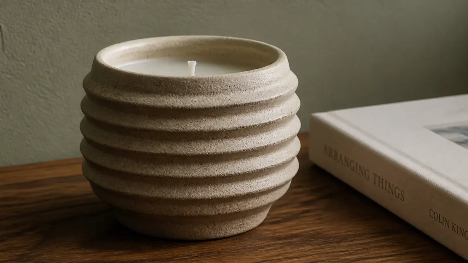 ribbed stoneware vessel candle adding texture to a plain coffee table