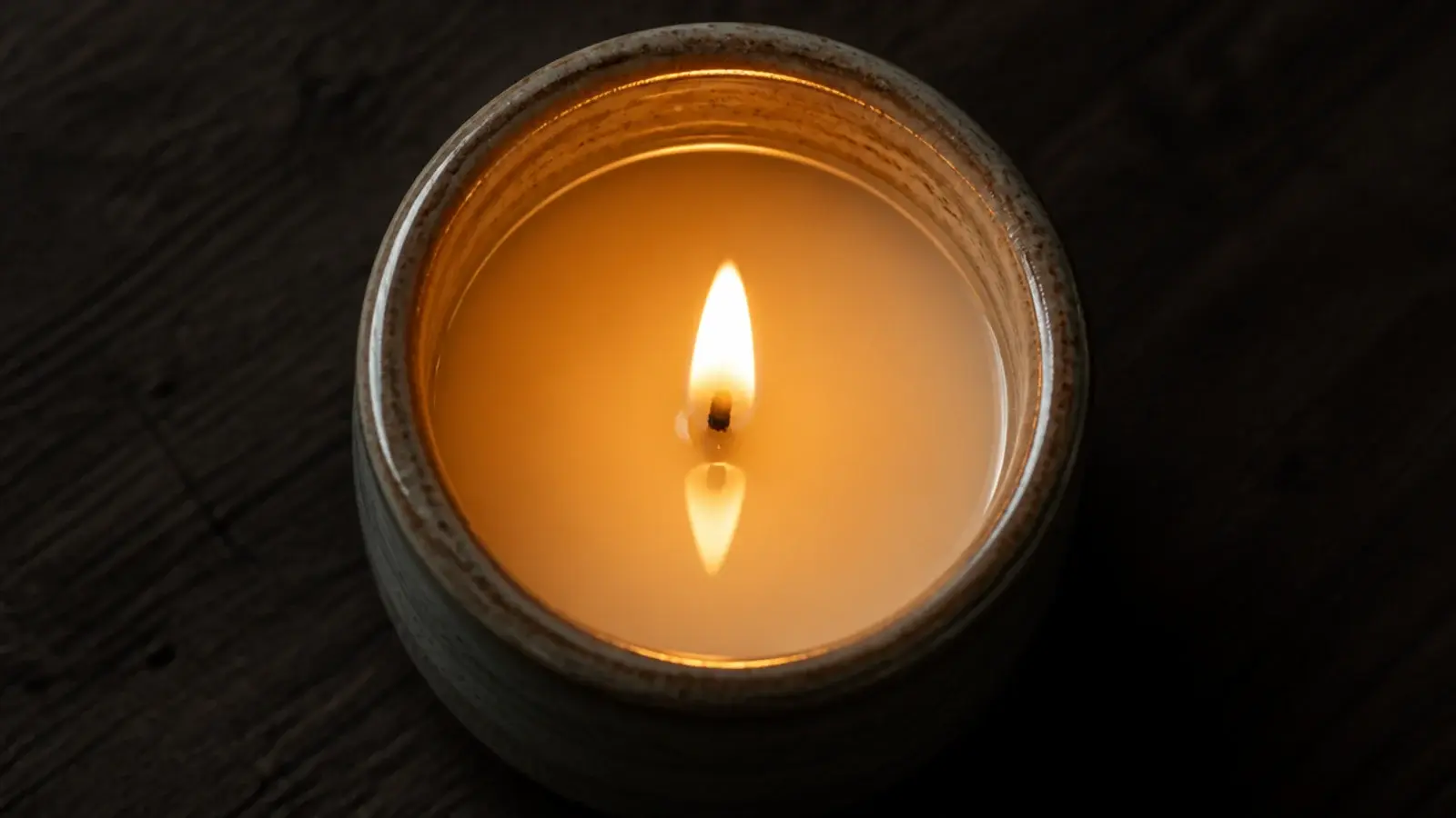 wide jar candle with melted wax reaching the full container diameter