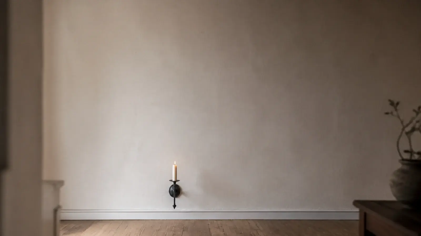 wall sconce with a tall empty span of plaster rising above the candle