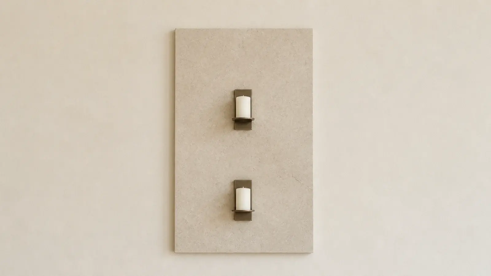 pale stone panel mounted behind two wall candles as a heat shield