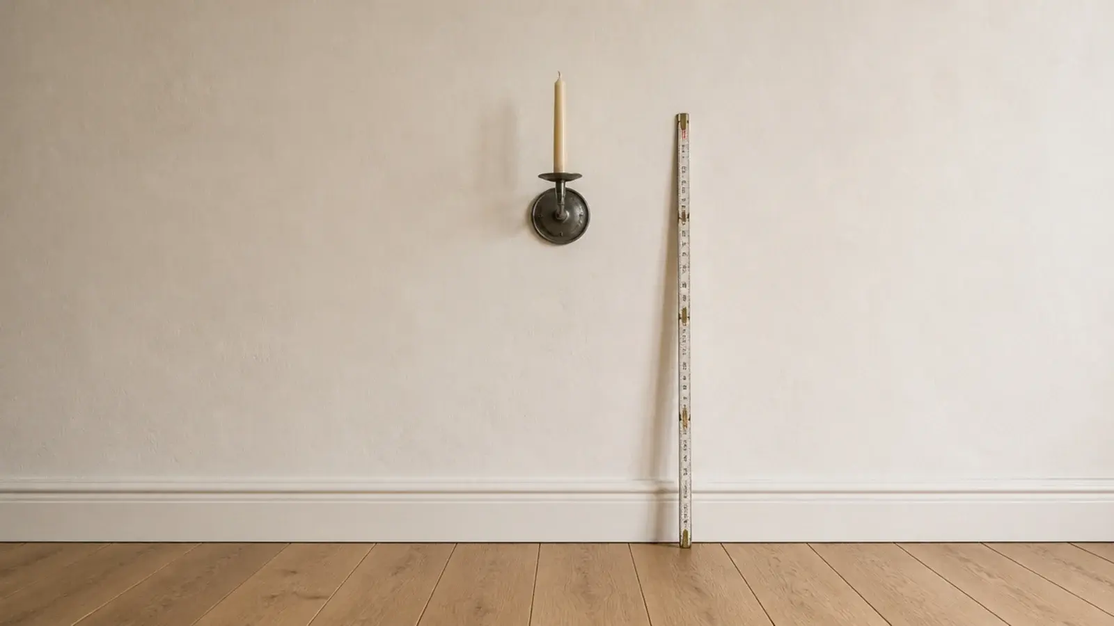 wall candle holder mounted at eye level on a plain plaster wall