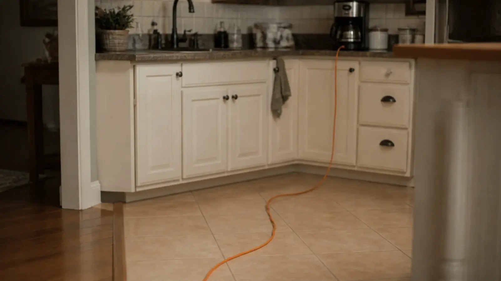 extension cord snaking across a kitchen floor toward a coffee station