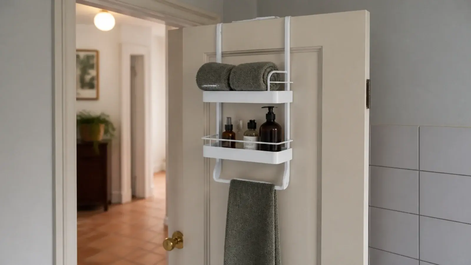 over the door rack in a bathroom corner holding towels and bottles