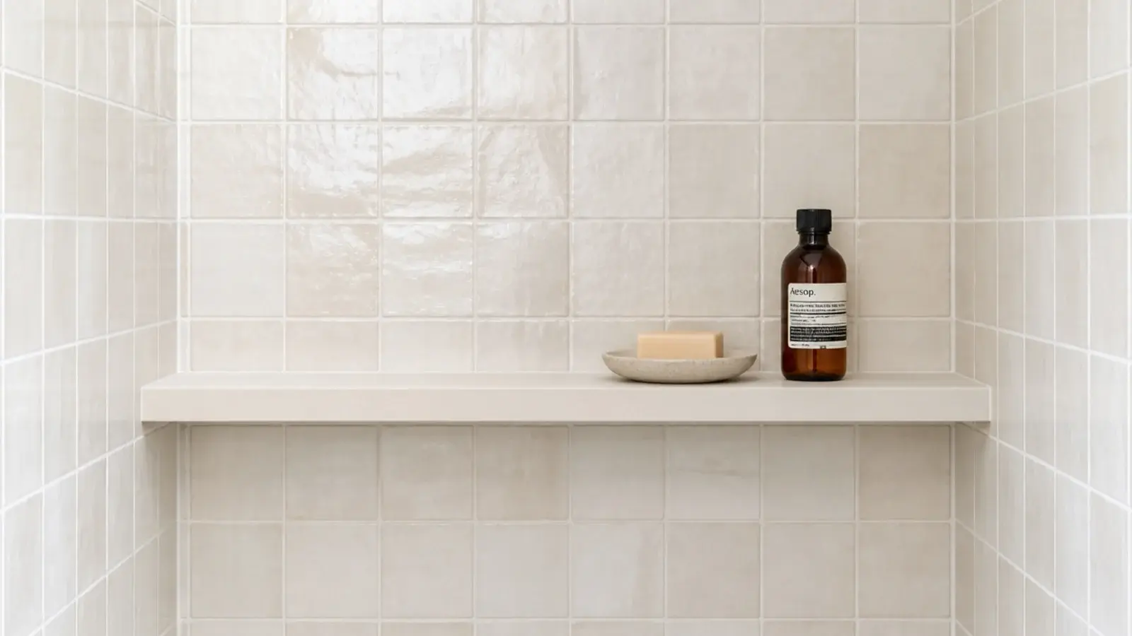 sealed solid surface floating shelf in a tiled shower corner