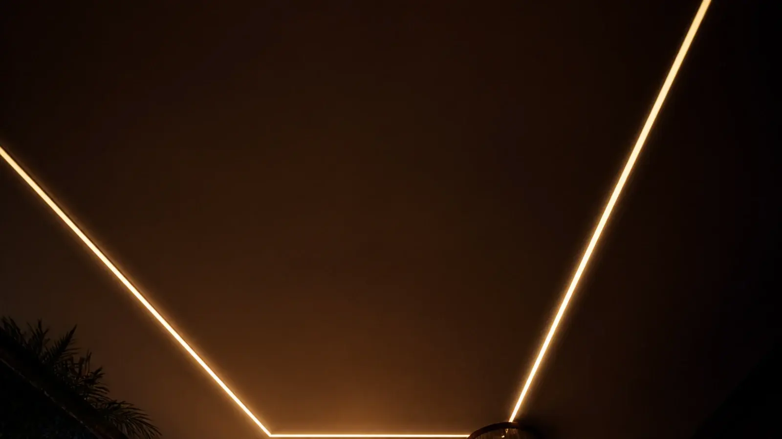 tall night view of a bedroom ceiling covered in warm fairy lights