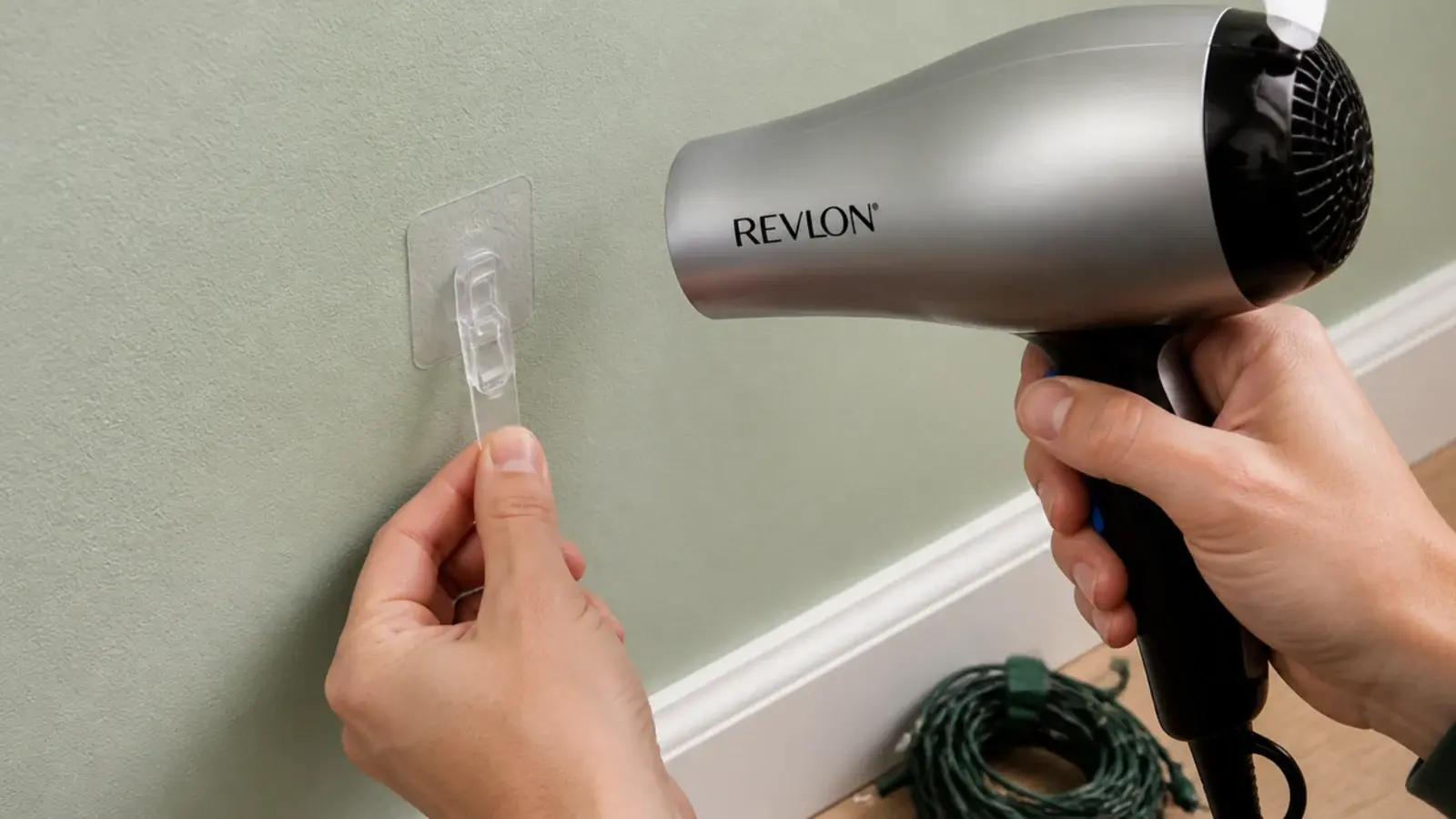 hairdryer warming an adhesive clip on a bedroom wall