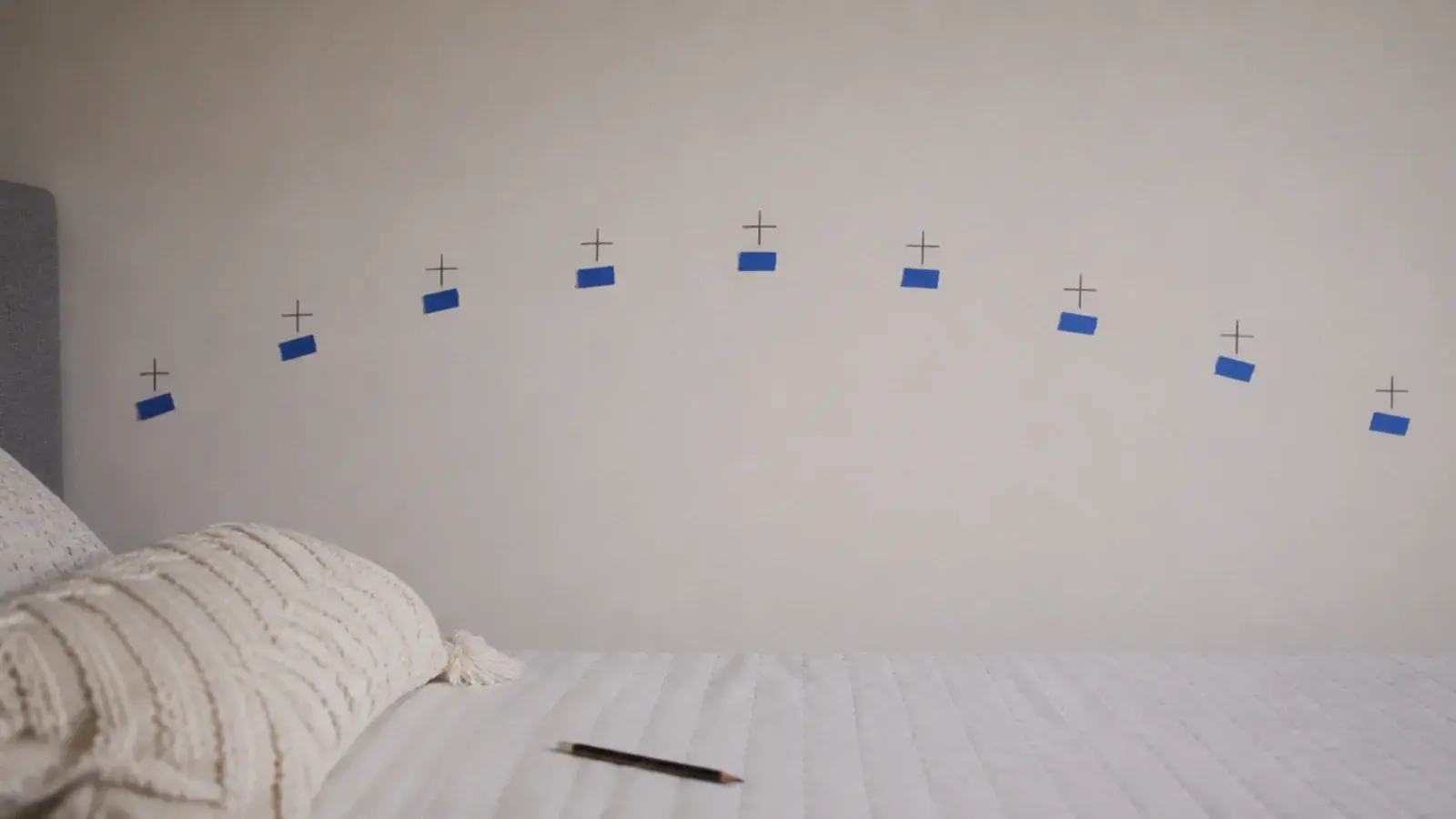 painter tape and pencil crosses marking a planned run on plaster