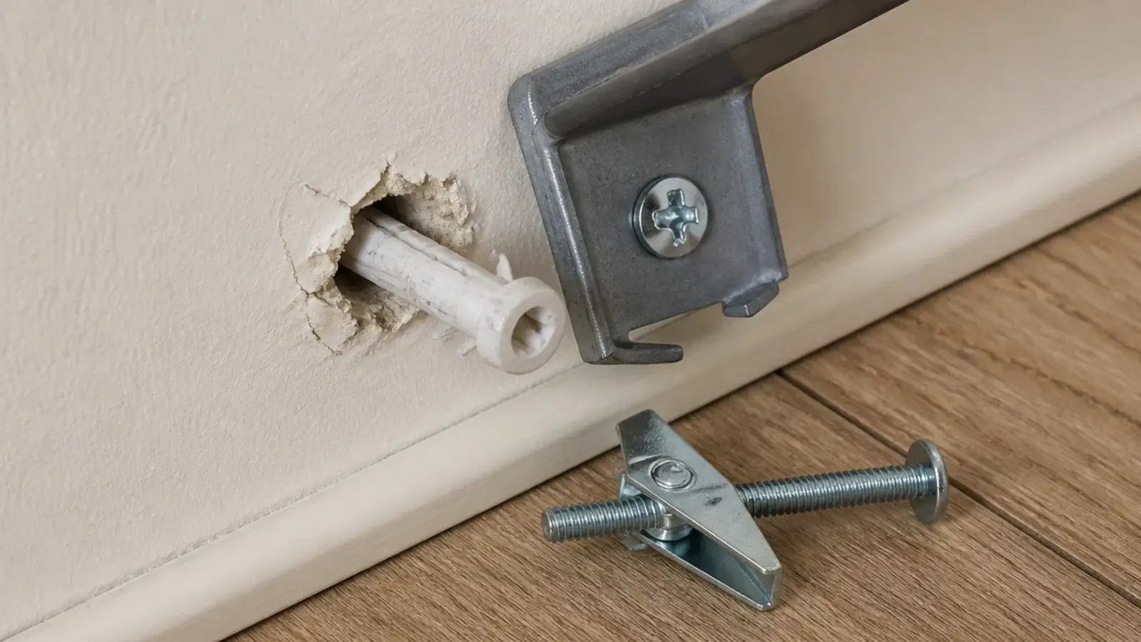 plastic wall plug pulled loose from drywall beside a floating shelf bracket