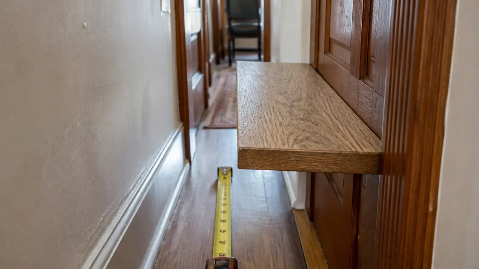 deep floating shelf jutting into a narrow hallway beside a doorframe