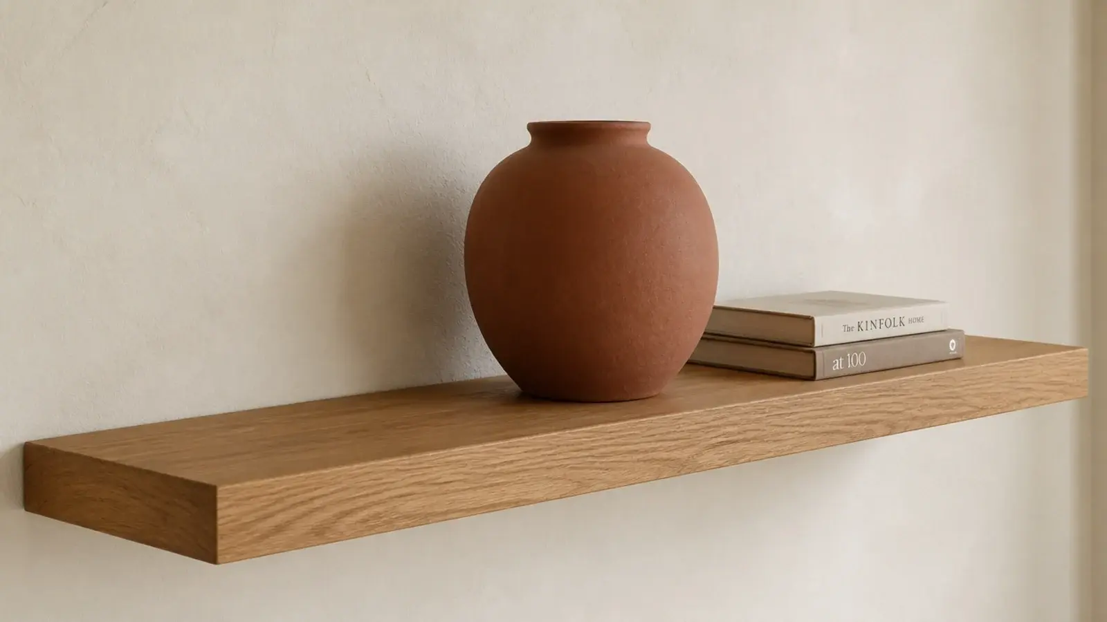 large stoneware vessel placed off centre on a floating oak shelf