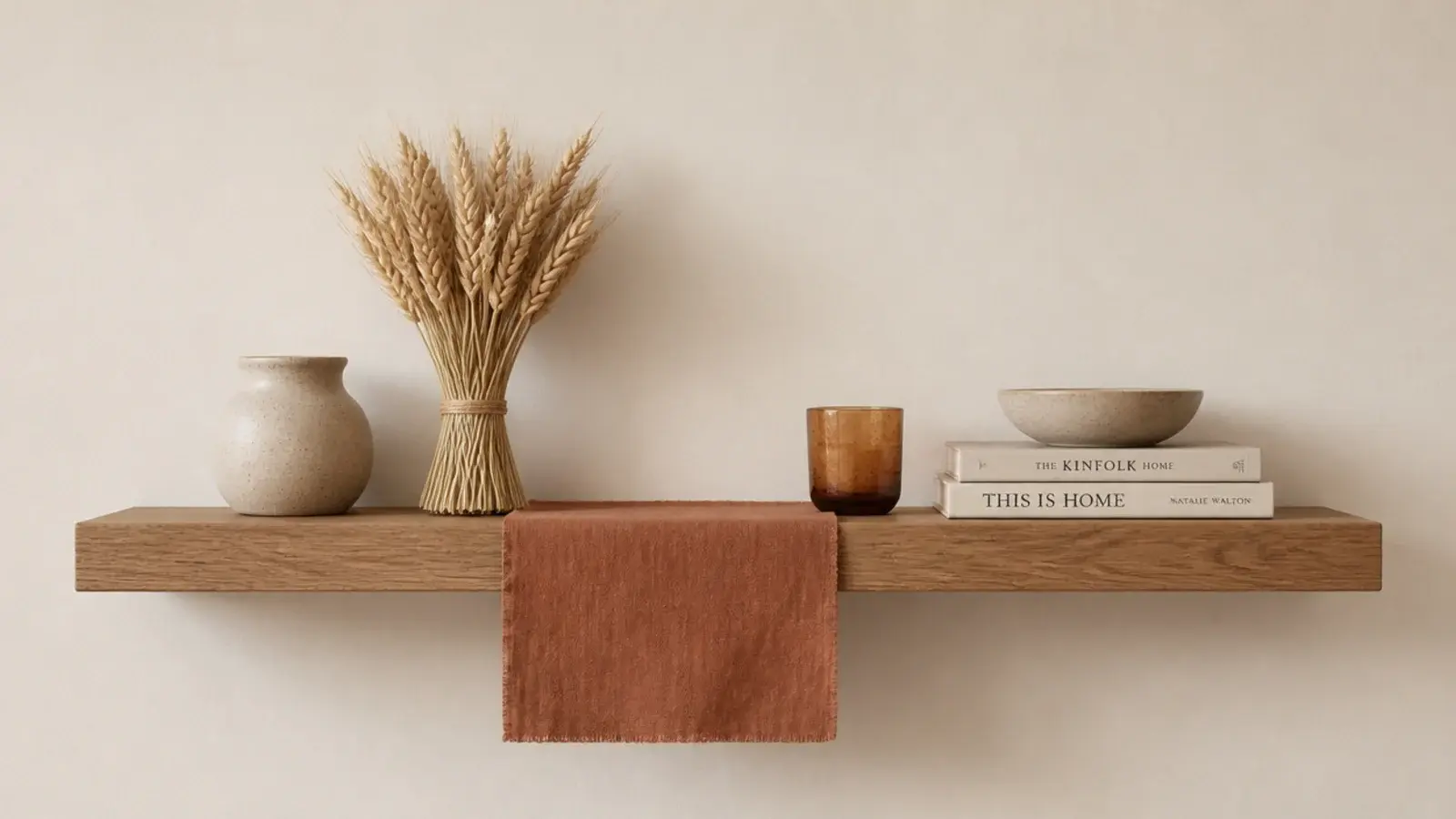 seasonal styling swap of stems and textiles on a floating shelf